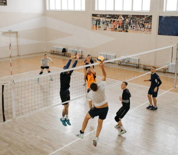 Boosting Athletic Performance Naturally - Group of Men playing volleyball indoors